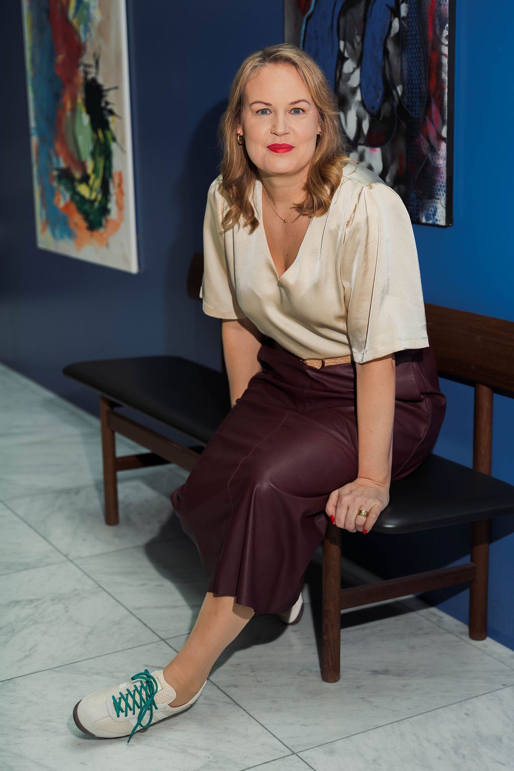 Jennie Zetterström sitter på en bänk framför en blå vägg